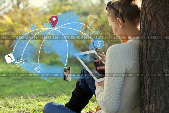 Concept of sitting young woman using her tablet pc during rest in the park. Стоковое фото, агентство Ingram Publishing / Фотобанк Лори