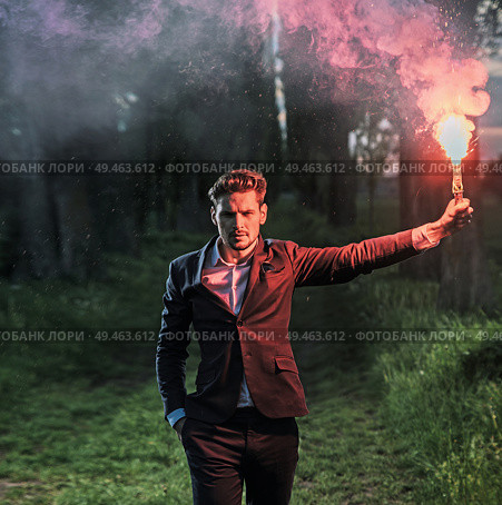 Conceptual portrait of an ambitious businessman holding a red flare. Стоковое фото, агентство Ingram Publishing / Фотобанк Лори