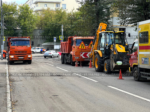 Construction equipment with a yellow excavator and orange dump trucks. Russia. Moscow. 19.08.25. Редакционное фото, фотограф Ярославский Максим / Фотобанк Лори