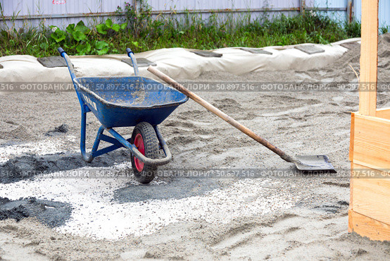 Construction site with wheelbarrow and spade on sand. Стоковое фото, фотограф Nobilior / Фотобанк Лори