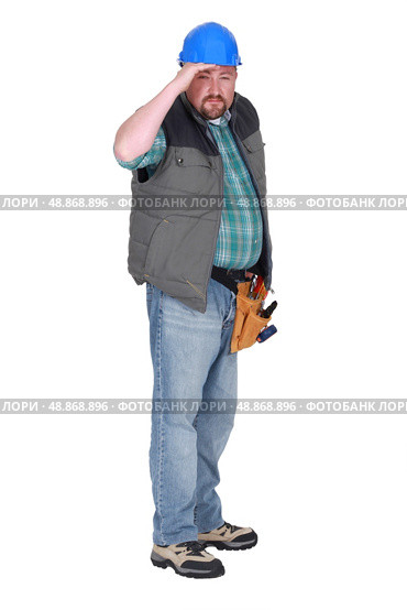 Construction worker squinting into the distance. Стоковое фото, агентство Ingram Publishing / Фотобанк Лори
