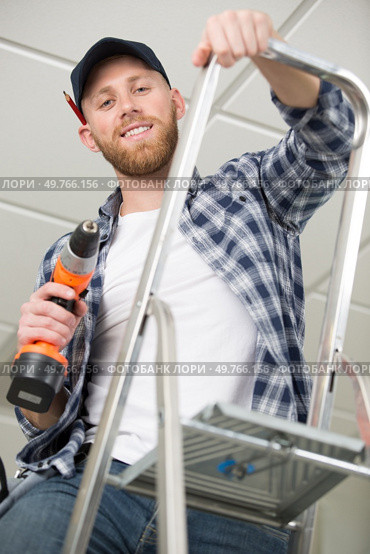 construction worker with power tool on stepladder. Стоковое фото, агентство Ingram Publishing / Фотобанк Лори