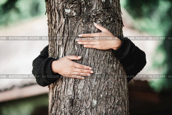 Contented young woman hugging a large tree with a blissful expression. Concept of care for environment. Стоковое фото, агентство Ingram Publishing / Фотобанк Лори