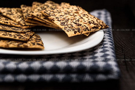 cookies with sunflower seeds and sesame seeds on a white plate with checkered napkin. Стоковое фото, агентство Ingram Publishing / Фотобанк Лори