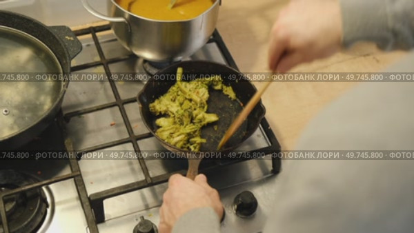 Cooking broccoli in a frying pan close-up. Homemade healthy, veggie food. Roasting broccoli on skillet pan. Chef hand stirring broccoli. Healthy food, vegetarian cuisine. Fry off broccoli stem. Стоковое видео, видеограф Марина Демидюк / Фотобанк Лори