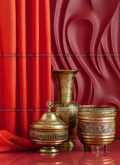 Copperware in oriental style on a red background with theatrical design. Стоковое фото, фотограф Olesya Tseytlin / Фотобанк Лори