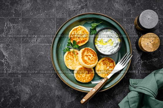 Cottage cheese fritters with greek yogurt tzatziki sauce, top view. Стоковое фото, агентство Ingram Publishing / Фотобанк Лори