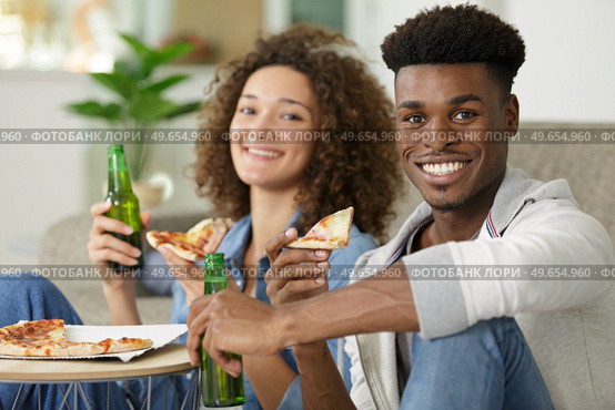couple bonding on box of pizza and beer. Стоковое фото, агентство Ingram Publishing / Фотобанк Лори