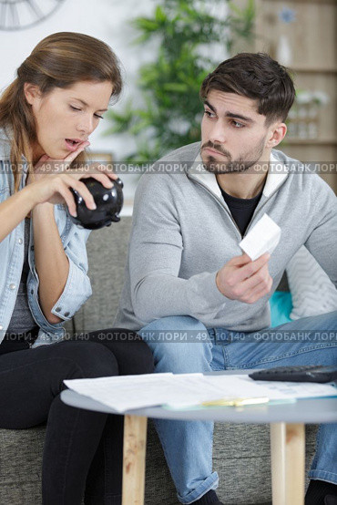 couple looking in dismay at their empty piggy bank. Стоковое фото, агентство Ingram Publishing / Фотобанк Лори