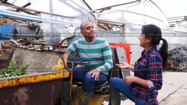 Couple of male and female hispanic workers talking and discussing something near forklift loader at farm. Стоковое видео, видеограф Яков Филимонов / Фотобанк Лори