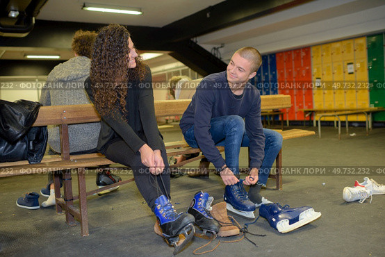 couple putting ice skates on. Стоковое фото, агентство Ingram Publishing / Фотобанк Лори