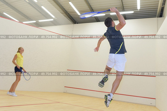 couple with squash rackets indoor training club. Стоковое фото, агентство Ingram Publishing / Фотобанк Лори