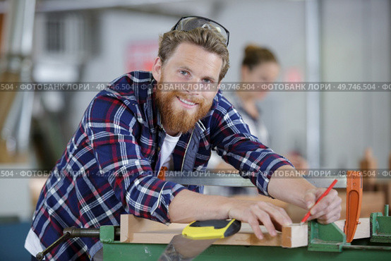 craftsman measuring with ruler and pencil on a wood board. Стоковое фото, агентство Ingram Publishing / Фотобанк Лори