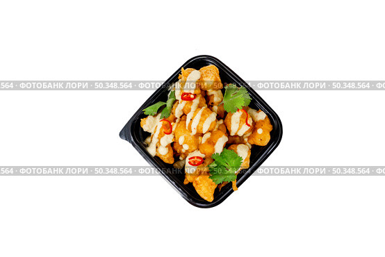 Crispy cauliflower bites drizzled with spicy sauce and garnished with herbs ready for takeout. Стоковое фото, фотограф Данила Большаков / Фотобанк Лори
