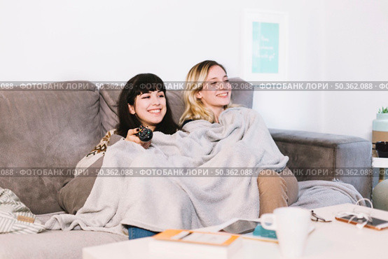 cuddling girl enjoying funny movie. Стоковое фото, агентство Ingram Publishing / Фотобанк Лори