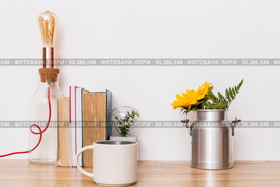 cup flowers tin can books lamp table. Стоковое фото, агентство Ingram Publishing / Фотобанк Лори