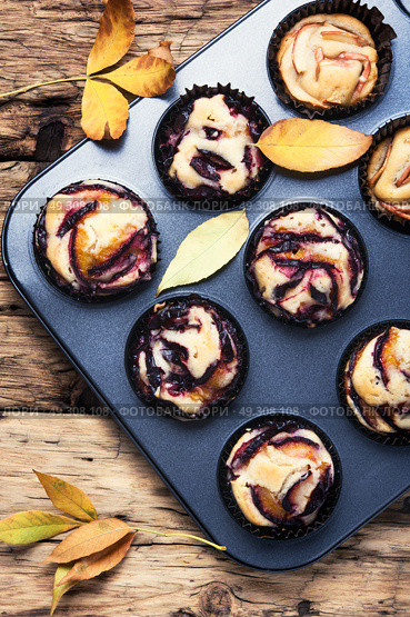 cupcake with plum. Plum cupcake on background with autumn leaves. Стоковое фото, агентство Ingram Publishing / Фотобанк Лори