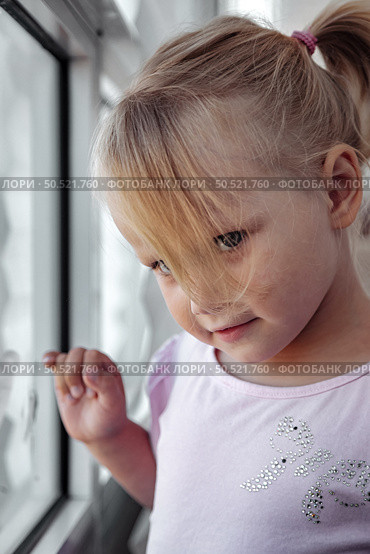 Curious Girl Gazes out the Window While Admiring the World Beyond Her Playful Imagination. Стоковое фото, фотограф Aleksandr Golubev / Фотобанк Лори