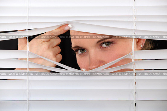 Curious woman peering through window blinds. Стоковое фото, агентство Ingram Publishing / Фотобанк Лори
