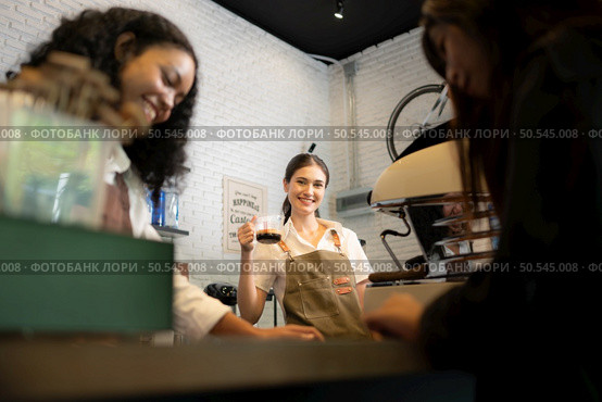 Customers select coffee items. with a young woman barista working at the coffee shop counter. Стоковое фото, агентство Ingram Publishing / Фотобанк Лори