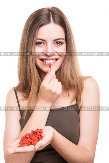 Cute girl eating a bunch of goji berries. Стоковое фото, агентство Ingram Publishing / Фотобанк Лори
