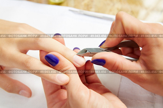Cuticle nippers tool in nails salon woman hands treatment. Стоковое фото, агентство Ingram Publishing / Фотобанк Лори
