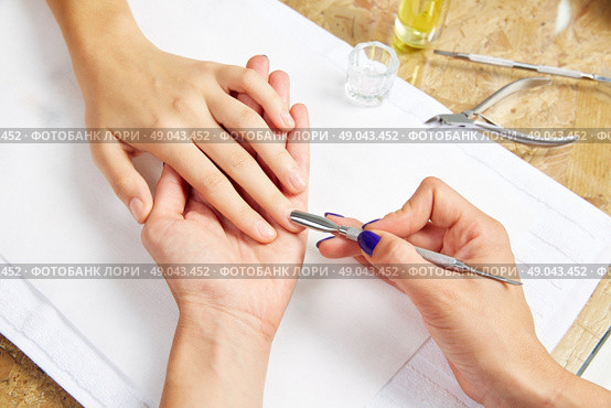 Cuticle pusher tool in nails salon woman hands treatment. Стоковое фото, агентство Ingram Publishing / Фотобанк Лори