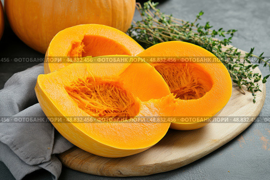 Cutting Fresh Pumpkins on Board. Baked pumpkin. Sliced raw Cucurbita maxima and spices for preparing soup, warm salad, fall dish. Thanksgiving food. Roasted vegetable in olive oil salt pepper, herbs. Стоковое AI-изображение, AI-художник Марина Демидюк / Фотобанк Лори