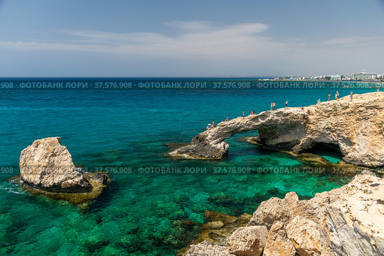 CYPRUS, THE BRIDGE OF LOVERS. Tourists jump from a height into the azure waters of the Mediterranean Sea (2018 год). Редакционное фото, фотограф Сергей Ляшенко / Фотобанк Лори