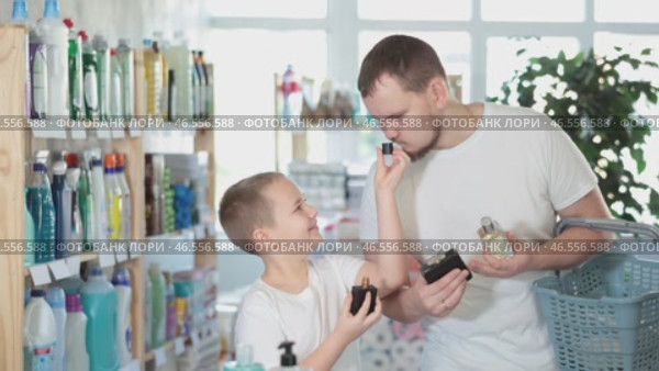 Dad and son client sniffs fragrance of perfume, chooses scent spray with pleasant smell. Стоковое видео, видеограф Яков Филимонов / Фотобанк Лори