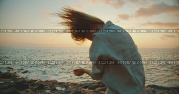 Dancer woman spinning gracefully by the ocean during golden hour. Стоковое видео, видеограф Ольга Сухарева / Фотобанк Лори