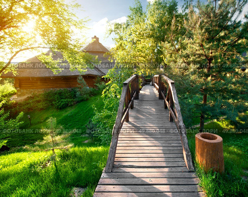 Decorative bridge near pines and wooden houses. Стоковое фото, агентство Ingram Publishing / Фотобанк Лори