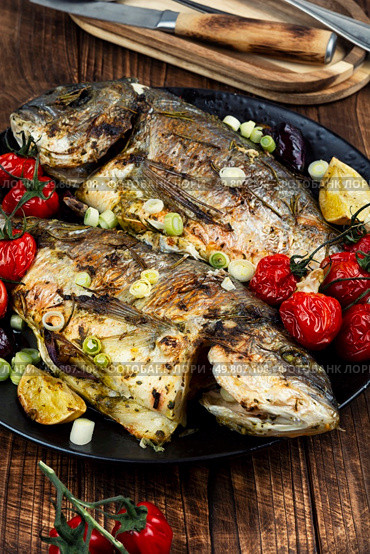 Delicious tasty baked dorado or sea bream fish with lime. Healthy eating.. Grilled sea bream or dorada. Стоковое фото, агентство Ingram Publishing / Фотобанк Лори