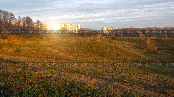 Delightful landscape of a hilly field at sunset. Tsaritsyno city Park in Moscow in the soft sun lights. Редакционное фото, фотограф Константин Григорьев / Фотобанк Лори