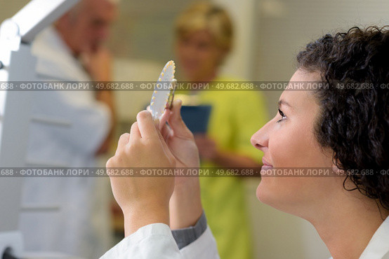 dental technician looking at prosthesis. Стоковое фото, агентство Ingram Publishing / Фотобанк Лори