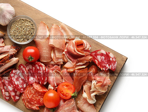 Деревянная доска с ассортиментом вкусных мясных деликатесов на белом фоне, крупным планом. Стоковое фото, фотограф Pixel_shot / Фотобанк Лори