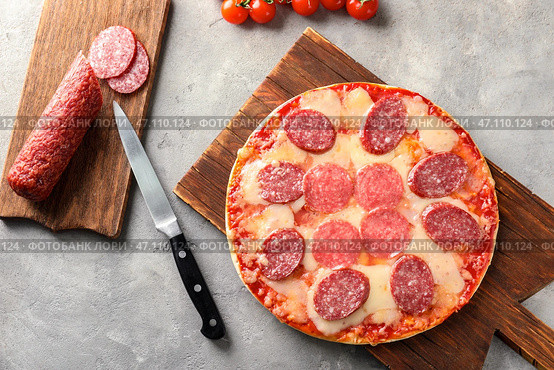 Деревянная доска с вкусной пиццей пепперони на столе. Стоковое фото, фотограф Pixel_shot / Фотобанк Лори