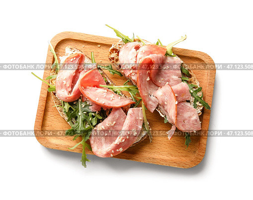 Деревянная доска вкусных брускетт с ветчиной на белом фоне. Стоковое фото, фотограф Pixel_shot / Фотобанк Лори