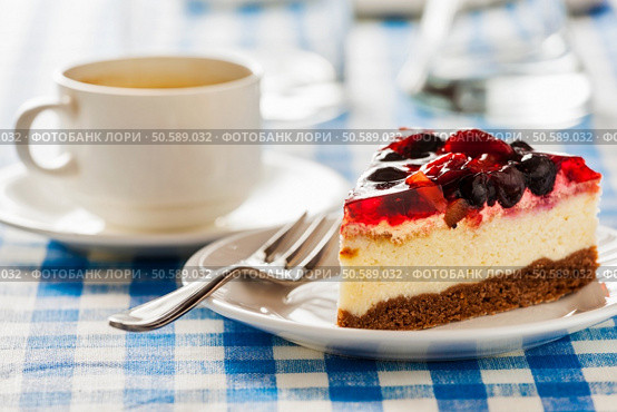 Dessert background - fruit cheese cake on plate with fork and coffee cup on blue checkered tablecloth. Стоковое фото, агентство Ingram Publishing / Фотобанк Лори