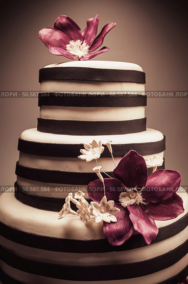 Details of a wedding or a birthday cake, triple size, in studio on white background. Purple sugar flowers as main decoration. . Стоковое фото, агентство Ingram Publishing / Фотобанк Лори