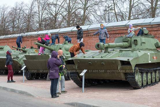 Дети играют на военной технике в парке Патриот весенним днем. Кронштадт (2022 год). Редакционное фото, фотограф Виктор Карасев / Фотобанк Лори