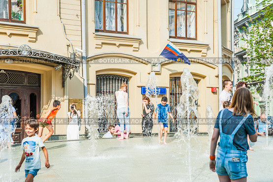 Дети играют в фонтане в жаркую погоду на Биржевой площади. Москва (2018 год). Редакционное фото, фотограф Алёшина Оксана / Фотобанк Лори