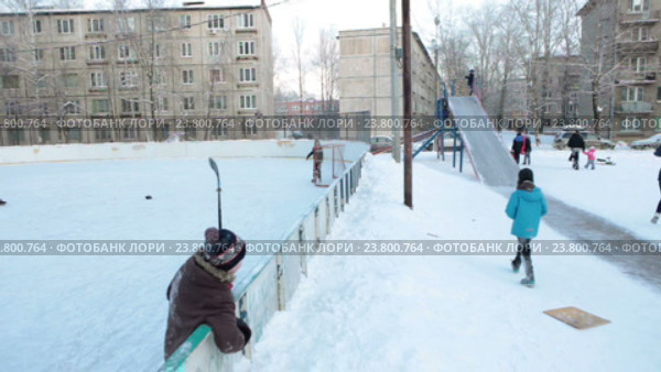 Дети играют в хоккей на дворовом катке и катаются с ледяной горки. Зима. Санкт-Петербург (2016 год). Редакционное видео, видеограф Кекяляйнен Андрей / Фотобанк Лори