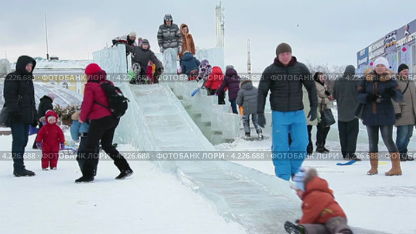 Дети катаются с ледяной горки на городской центральной площади, Дмитров (2013 год). Редакционное видео, видеограф Кекяляйнен Андрей / Фотобанк Лори