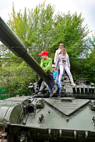 Дети увлечено  играют на танке Т-72. Российская боевая техника. Город Тюмень (2024 год). Редакционное фото, фотограф Александр Тараканов / Фотобанк Лори
