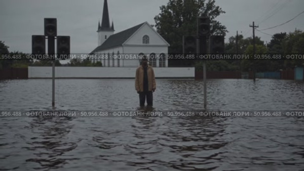 Devastating floodwaters surrounding lone figure and loudspeakers near church building, depicting climate change impact on vulnerable urban environment. Стоковое AI-видео, аниматор Данил Руденко / Фотобанк Лори