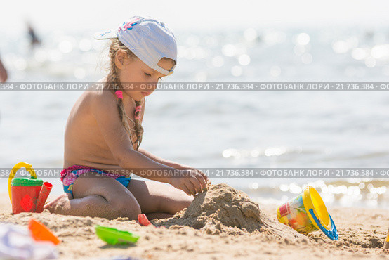 Девочка на пляже морского побережья играет в песочке. Стоковое фото, фотограф Иванов Алексей / Фотобанк Лори