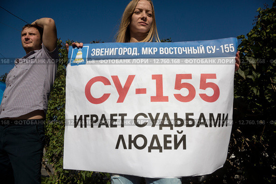 Девушка держит плакат с надписью "СУ-155 играет судьбами людей" на Всероссийском митинге обманутых дольщиков строительной компании СУ-155 на Суворовской площади города Москвы, Россия, 26 сентября 2015. Редакционное фото, фотограф Николай Винокуров / Фотобанк Лори