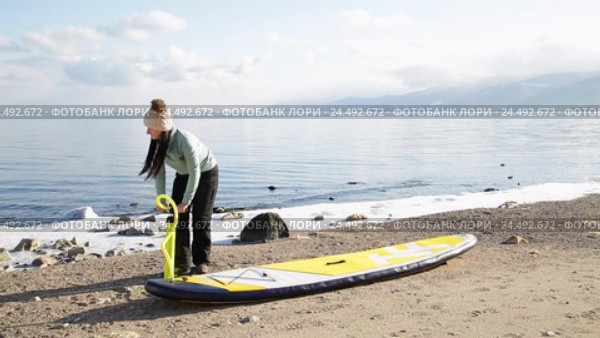 Девушка готовится плавать на sup board по зимнему озеру в Сибири. Озеро Байкал. Стоковое видео, видеограф Виталий Зверев / Фотобанк Лори