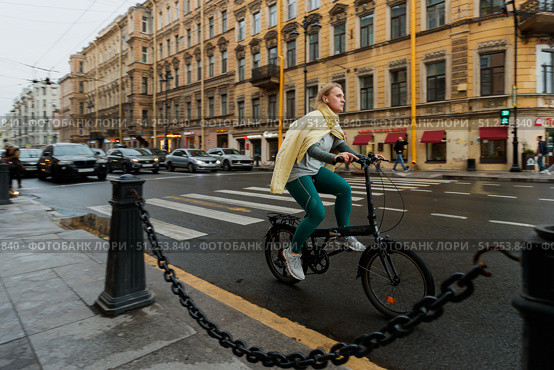 Девушка на складном велосипеде едет по улице исторического центра города. Редакционное фото, фотограф Кирилл Сиротюк / Фотобанк Лори